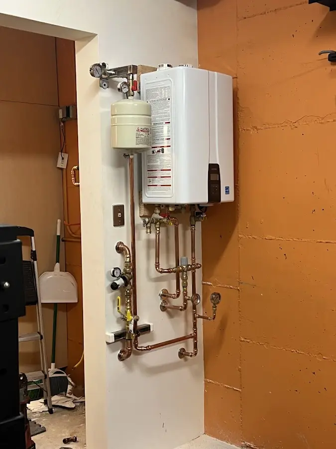 Plumbing technician inspecting water heater connections in Saline